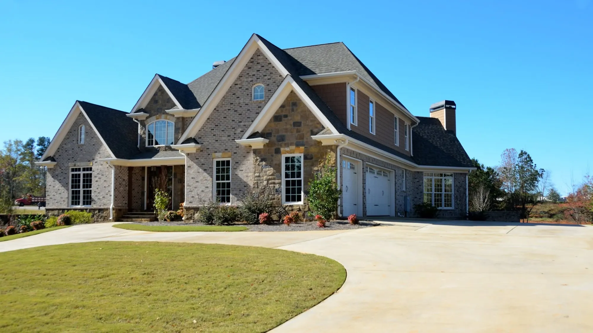 Brick and stone estate home with a circular drive
