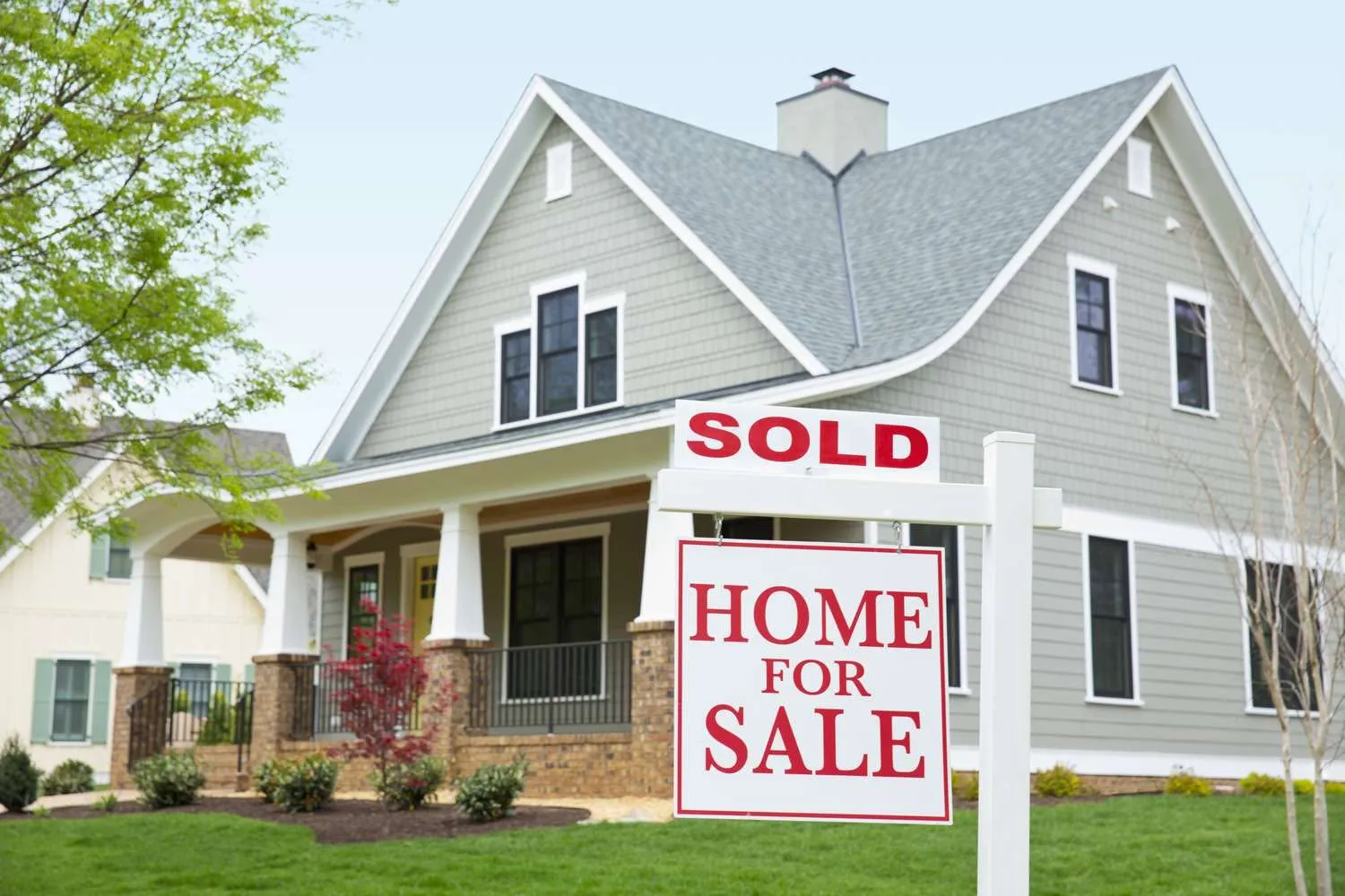 A sold sign in front of a craftsman style home