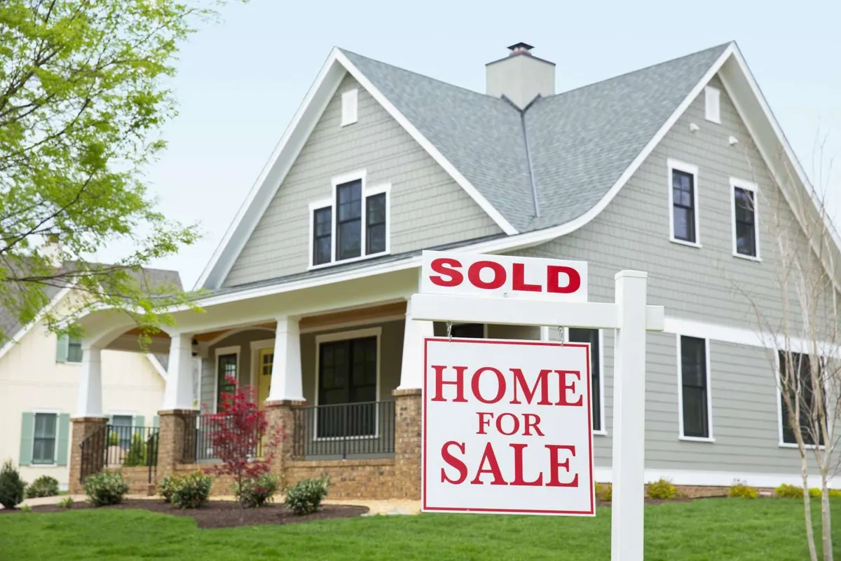 A sold sign in front of a craftsman style home