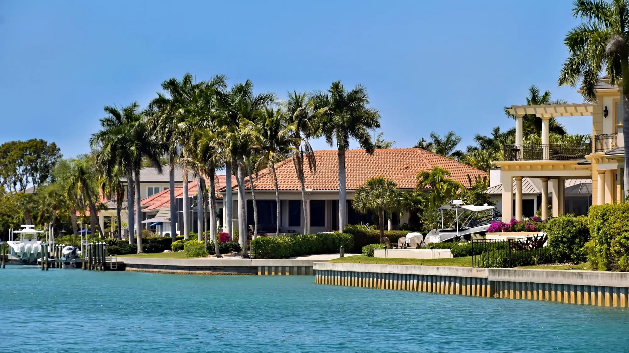 Waterfront villas and palms under a clear sky