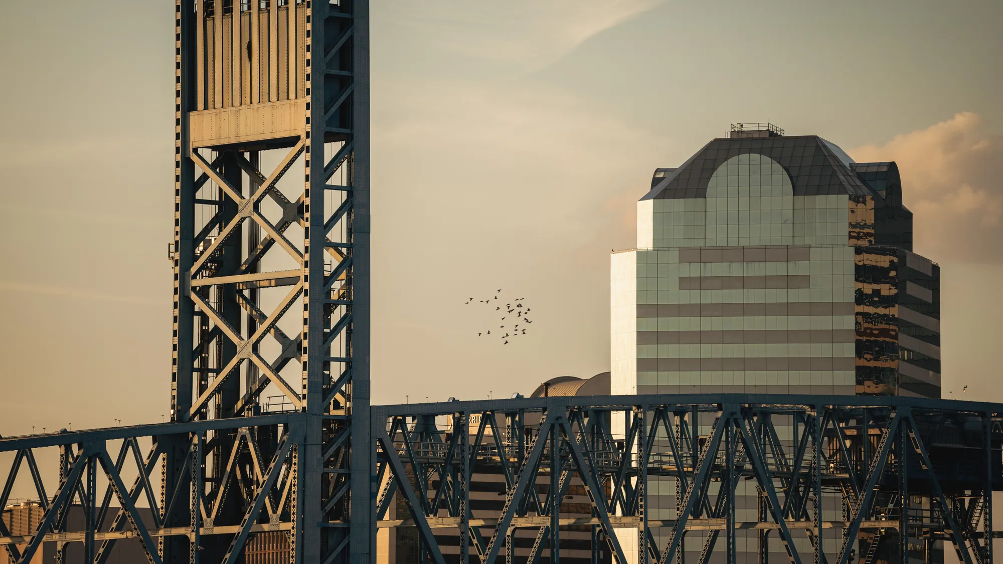 A steel bridge and downtown building in Jacksonville, Florida at sunset