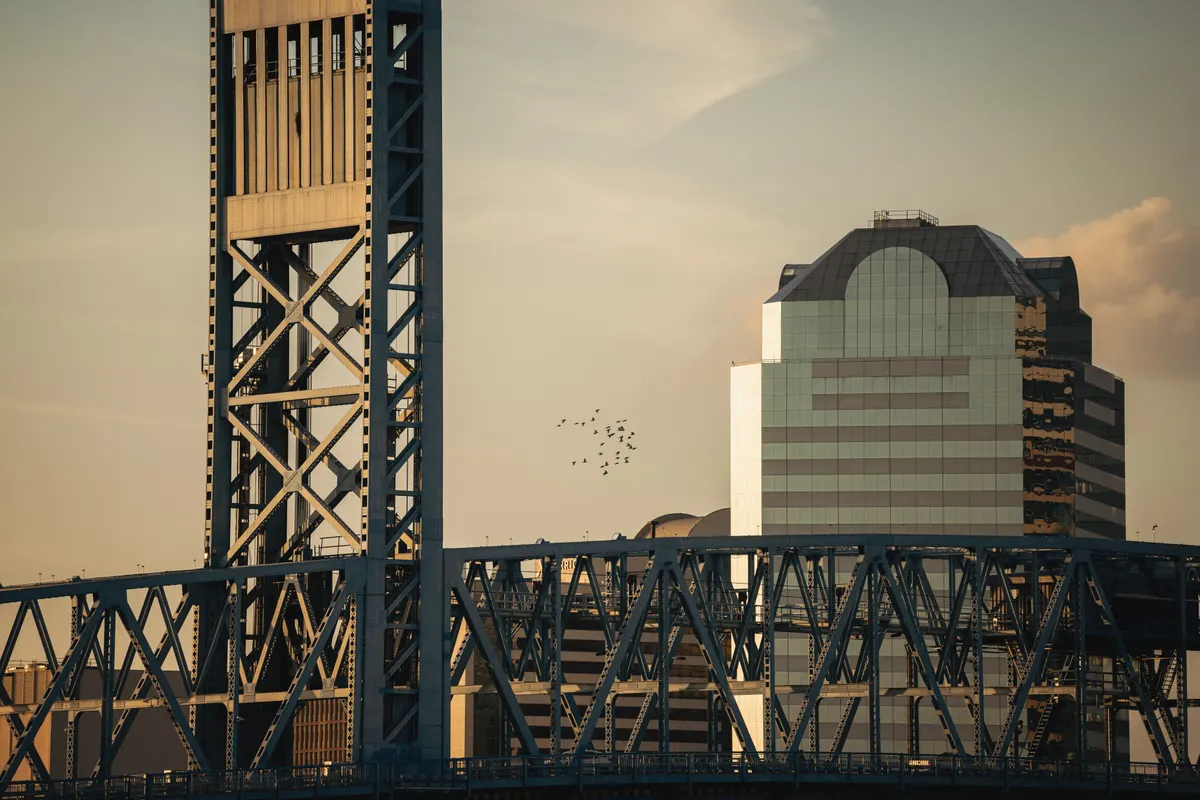 A steel bridge and downtown building in Jacksonville, Florida at sunset