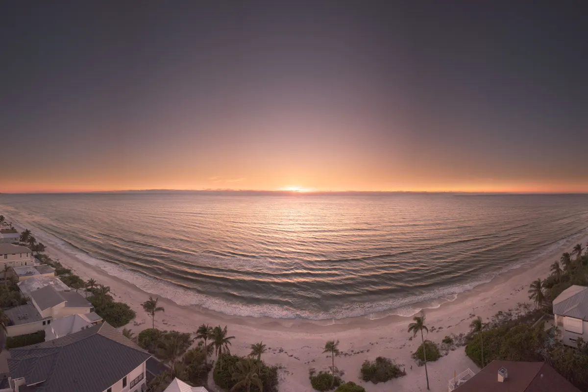 Houses lining the shore at sunset, seen from above